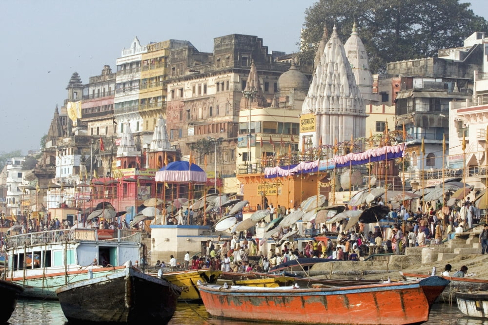 Hindu pilgrims immersed in the waters at the bathing ghats Photograph taken while being rowed on the sacred but polluted River Ganges The culture of Varanasi is closely associated with the River Gange