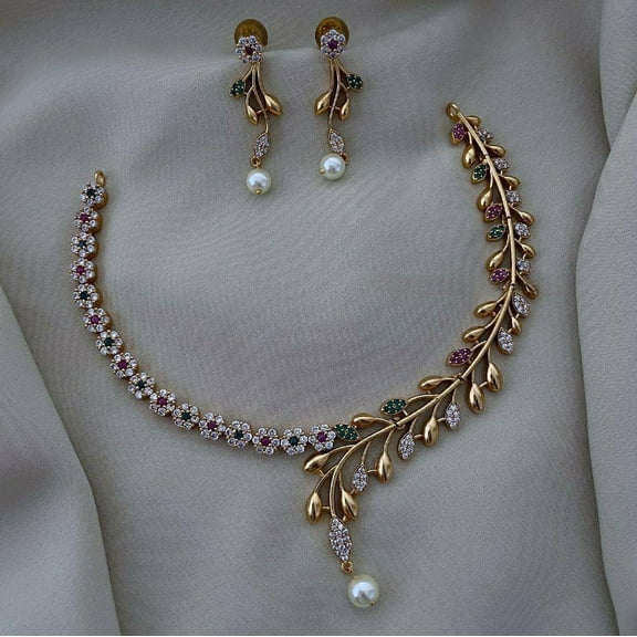 South Indian Bollywood Floral Leaf Gold-Plated Short Necklace Set – Ruby, Green & White Kemp Stones with AD CZ, Matte Finish Alloy Brass & Pearl Detailing, Drop Earrings Included.