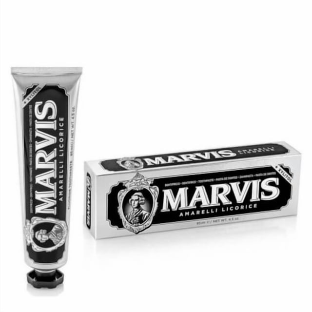 pasta de dientes de regaliz amarelli marvis 85ml tubo metálico y caja frontales; tubo con tapa hexagonal negra y etiqueta vertical blanca y negra con logo MARVIS y texto "Amarelli Licorice"; caja rectangular blanca con franja negra y retrato clásico enmarcado. A menudo usada como pasta dental aromática para higiene bucal diaria.