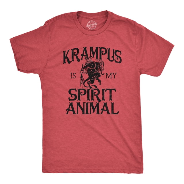Mens Krampus Is My Spirit Animal T Shirt Funny Xmas Saint Nicholas Folklore Tee for Guys in heather red, size small. The short-sleeve t-shirt features a black graphic of Krampus with the text 'Krampus Is My Spirit Animal' in bold, distressed font. Made from super soft cotton, this slim-fit tee is machine washable and designed by Crazy Dog T-Shirts in the USA.