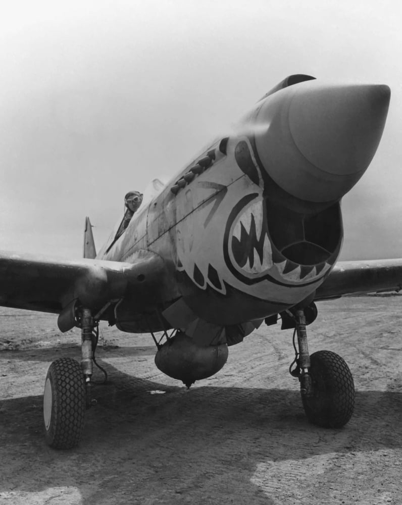 Vintage World War Two image of a P-40 Warhawk plane with a Flying