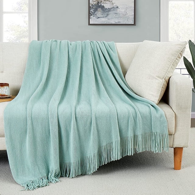 HTOOQ Couverture Jetée Décorative en Tricot avec Franges Vert Pâle, Drapée sur un Canapé beige dans un Salon Douillet. Fabriquée en Acrylique Façon Laine, Cette Couverture à Pompons Douce et Confortable Est Parfaite pour Canapés, sofas, Lits Ou comme Pièce d'Accent de Déco Maison.