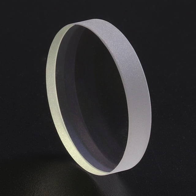 lente de protección láser de cuarzo ventana protectora de seguridad para soldadura por corte láser (37 x 7) lente circular de cuarzo 37×7 mm en vista 3/4 frontal; borde mate y canto biselado, recubrimiento doble que muestra reflejos violetas y verdes; pensada para montarse en el cabezal de corte láser y proteger la lente de enfoque en máquinas >200 W. También adecuada como repuesto protector en talleres de corte y soldadura.