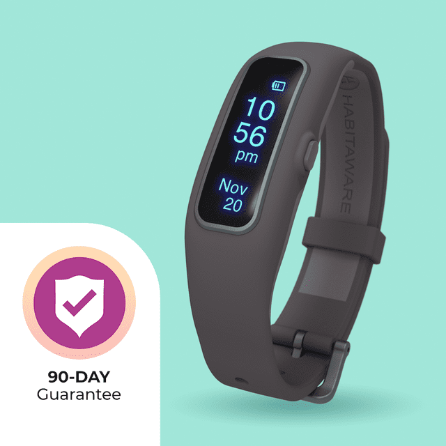 Keen2 Awareness Bracelet for Hair Pulling, Skin Picking and Nail Biting, shown in a sleek dark grey design with a digital display showing the time and date. The bracelet is designed to help users build awareness and control over habits like trichotillomania and dermatillomania. A 90-day guarantee badge is visible in the corner.