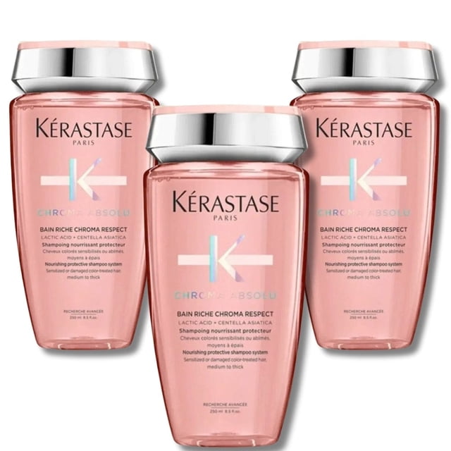 Kérastase Chroma Absolu Bain Riche Shampooing Nourrissant et Protecteur pour Cheveux Colorés 250 ml Lot de 3. l'Image Montre Trois Bouteilles de Shampooing avec un Motif Rose et des Capsules Argentées, Présentant le logo Kérastase et les Détails du Produit sur l'Étiquette. Convient pour Maintenir l'Éclat et Protéger les Cheveux Colorés.