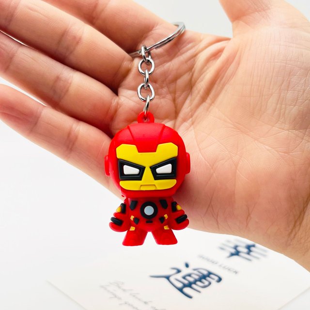 llavero de la serie de los vengadores de marvel — llavero de Iron Man estilo dibujo animado, vista frontal centrada en rojo y amarillo, figura con máscara y detalle de pecho, cadena y aro metálico sujetado en la mano sobre fondo blanco; accesorio para bolso o llavero de colección.