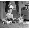 Two boys playing with toy game on living room floor Poster Print