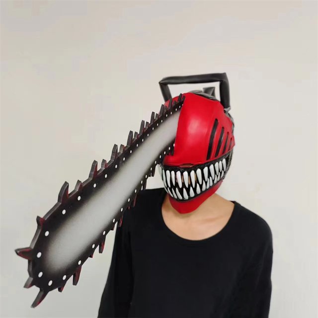 casco de motosierra hombre cosplay denji máscara chainsawman látex halloween casa de los tesoros casco tipo motosierra rojo con hoja dentada lateral, vista 3/4 frontal sobre busto. Casco integral en látex y EVA con boca pintada de dientes blancos, ranuras negras en los lados, empuñadura negra superior y hoja dentada gris con degradado oscuro y puntas rojizas; modelo con camiseta negra y fondo neutro. Diseñado para cosplay, Halloween y eventos de disfraces; suele emplearse también como accesorio para sesiones fotográficas de anime.