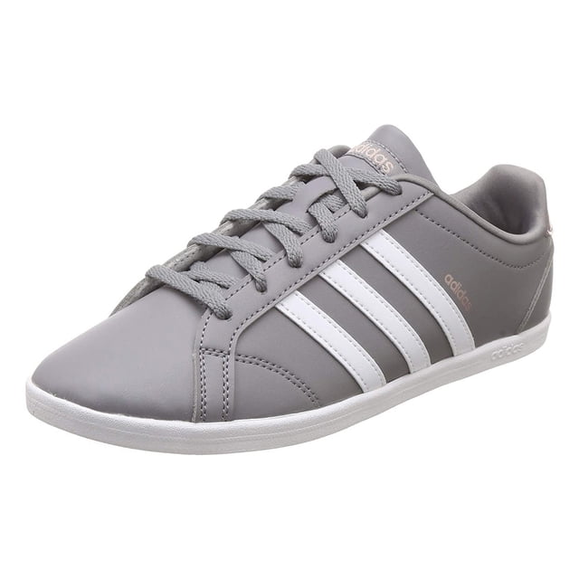 tenis adidas mujer gris coneo qt b44687 Tenis casual gris con exterior en cuero sintético y 3 franjas blancas de acabado brillante, vista 3/4 frontal centrada; refuerzo de talón en charol sintético, cordones grises, forro interno de tela, plantilla Confort y suela cupsole delgada de caucho. Ideal para look clásico y uso diario; frecuentemente usados también para caminatas urbanas cortas.