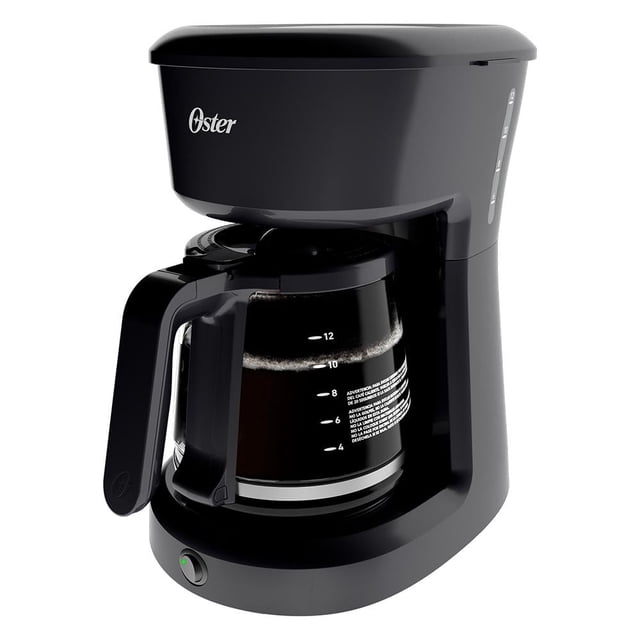 cafetera oster análoga 12 tazas negra, vista 3/4 frontal de cafetera eléctrica Oster para 12 tazas con jarra de vidrio graduada y mango negro; acabado negro, tapa superior y botón indicador en la base, base con compartimiento para guarda cable y filtro permanente visible; potencia 1000 W y función servir durante el colado; a menudo usada para preparar varias tazas en casa.