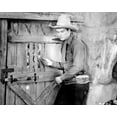 thumbnail image 1 of John Wayne in early 1930's western wearing tall hat & gunbelt 5x7 inch photo, 1 of 1