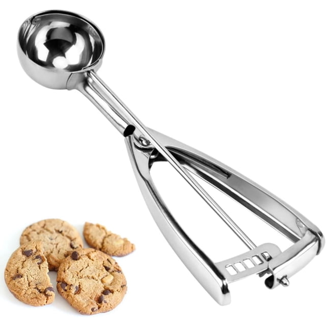 cuchara para galletas, cuchara para helado, acero inoxidable 18/8 de 2 cucharadas (30 ml). Vista 3/4 con cucharón redondo de 44 mm, mango con gatillo, mecanismo de trinquete y raspador de acero; fondo blanco y galletas que muestran uso para porcionar masa o servir helado.