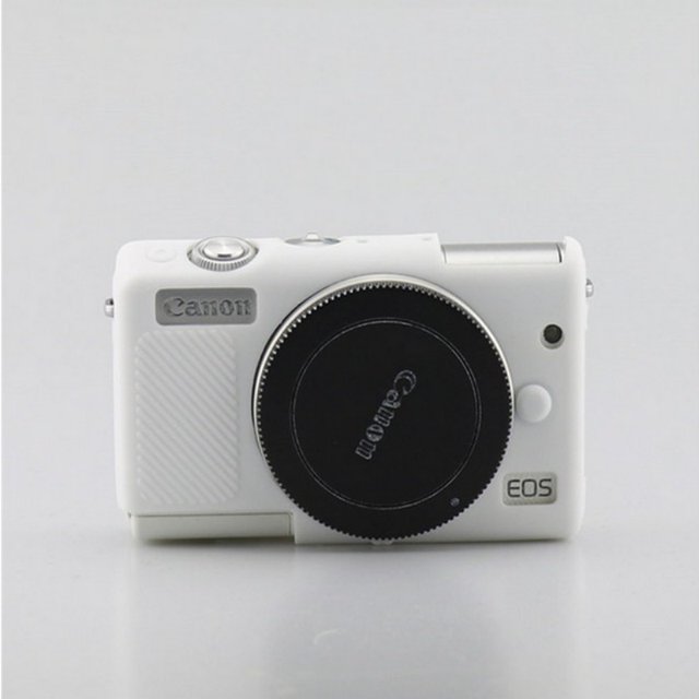 Camera Soft Silicone Skin Cover for Canon EOS M100 and M200, shown in white. This protective case, made of durable silicone, is designed for point-and-shoot cameras, offering a snug fit around the camera body. The image displays a front-facing view of the camera with the cover applied, highlighting its textured grip, precise cutouts for buttons, and lens access. Suitable as a camera bag alternative for added protection.