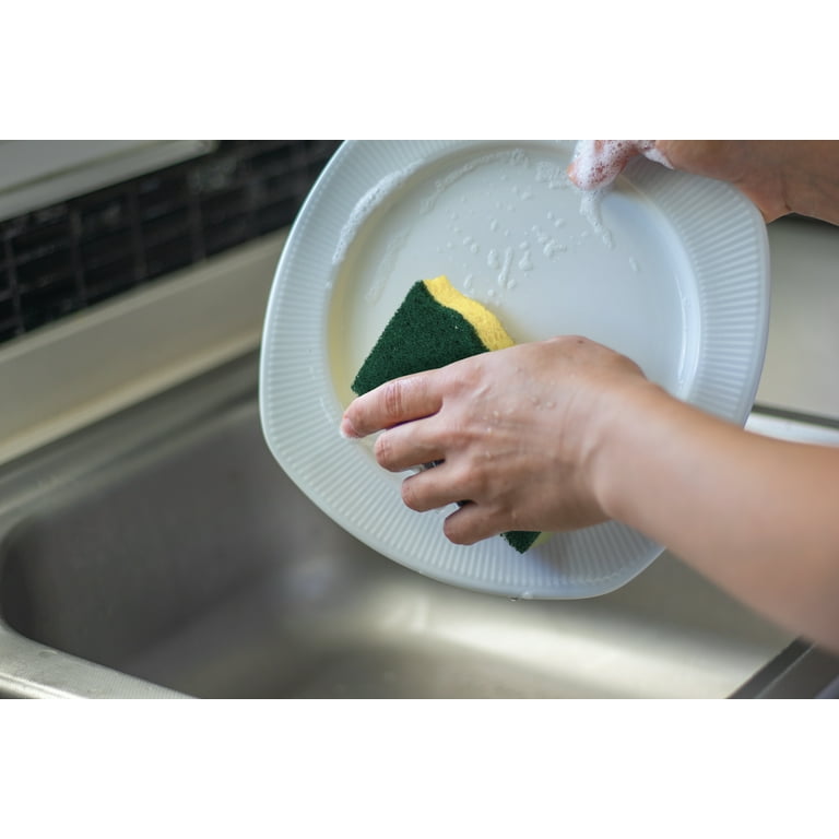 Doug washes dishes with a power scrubber