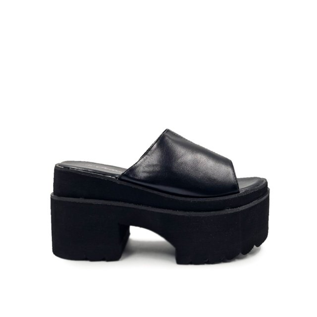 sandalia con plataforma genérica negra de piel ecológica, plataforma de 9,5 cm Vista lateral perfil de sandalia con pala ancha de piel ecológica negra sobre suela de plataforma negra de 9,5 cm con tacón bloque y ranuras en la base; fondo blanco, estilo casual urbano, a menudo usada para dar altura y estilizar conjuntos diarios.