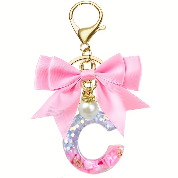 A Stylish Resin Letter Keychain Featuring a Bow And Pearl, Perfect for Women, Students, And As a Small Gift for Hanging on Bags.
