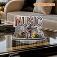 thumbnail image 4 of Rotating acrylic display features MUSIC letters with a guitarist on stage surrounded by musical notes and accessories in a vibrant composition, 4 of 7