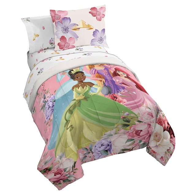 juego de ropa de cama jay franco disney princess completo con 7 piezas juego matrimonial; edredón multicolor (76 x 86 in) con ilustraciones de Cenicienta, Ariel, Rapunzel y Tiana en estilo animado, vista 3/4 frontal que muestra edredón, sábana encimera con motivos florales (81 x 96 in), sábana bajera ajustable con bolsillos profundos (54 x 75 x 10 in) y cuatro fundas de almohada; 100% poliéster microfibra cepillada, patrón floral en los bordes y fondo claro.