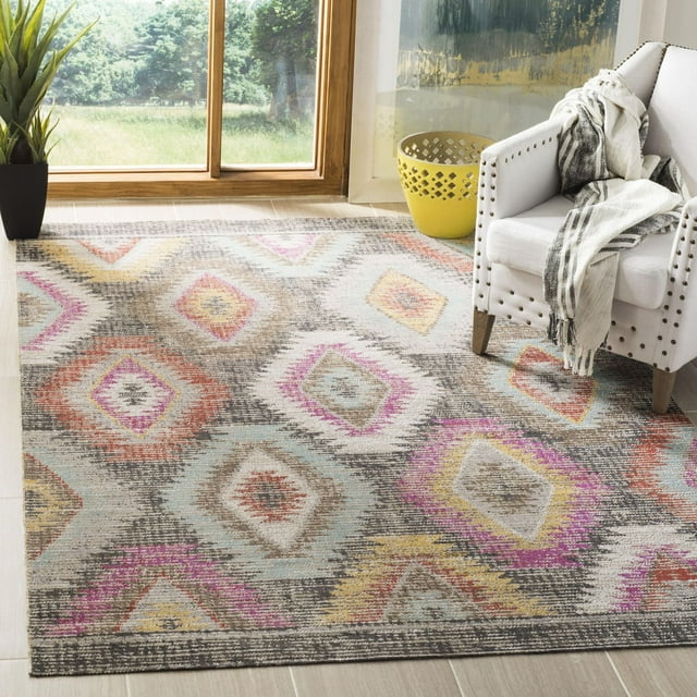 SAFAVIEH Montage Weston indoor/outdoor area rug featuring multicolored geometric diamond designs, displayed in a bright room with natural light, next to a white studded armchair and decorative plant.