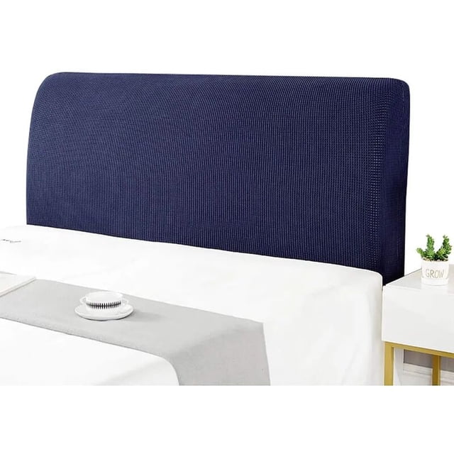 funda de cabecera, funda de base de cama acolchada de color sólido, funda de cabecera elástica todo incluido a prueba de polvo. Vista frontal centrada de funda elástica color azul marino con tejido de punto y silueta rectangular, colocada en cama con sábanas blancas y camino gris; ajuste para cabeceras de 70 cm a 1,8 m, lavable y fácil de montar. También se usa a menudo para proteger la parte trasera del cabezal durante mudanzas o almacenamiento.