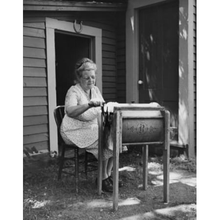 Senior woman churning butter in a butter churn Canvas Art - (18 x 24)
