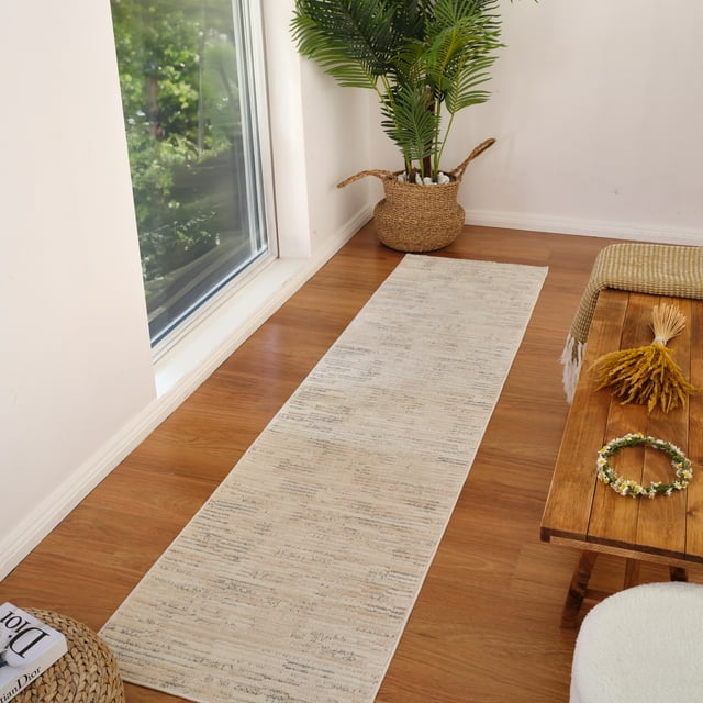 Modern beige cream abstract indoor runner rug on wood floor next to window, styled with woven basket plant and wooden bench.