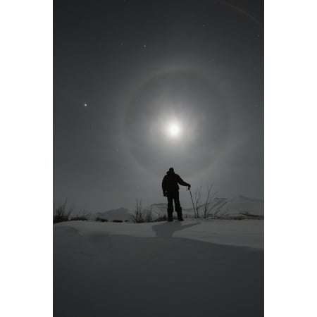 Man snowshoeing along the Dempster Highway under a moon glowing with rings Yukon Canada Canvas Art - Robert Postma Design Pics (12 x 19)
