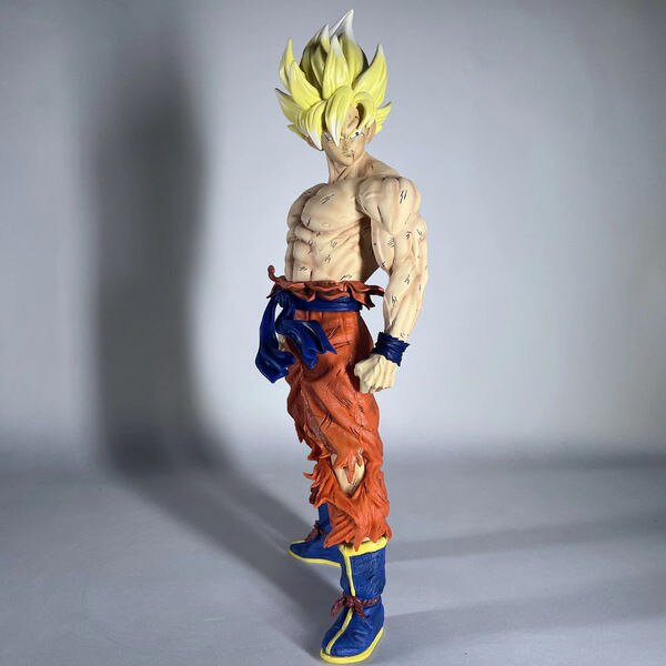 43cm anime dragon ball z kd battle damage super saiyan son goku figura de acción de gran tamaño figura de pvc modelo muñeca juguete para regalozhangyuxiang figura de Goku Super Saiyan de 43 cm en vista 3/4; figura de PVC con cabello amarillo erizado, torso musculoso con marcas de batalla, pantalones naranja rasgados con faja azul y botas azules; embalaje en bolsa o caja OPP, recomendada para 12+.