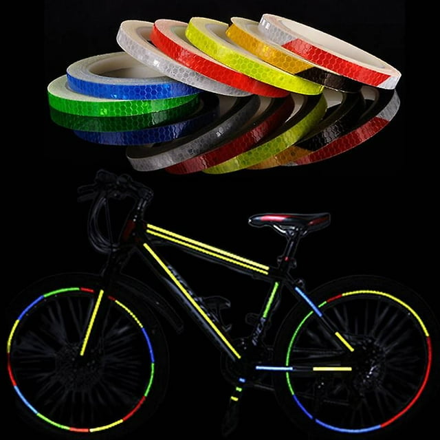 pegatina para bicicleta, pegatinas reflectantes, tira de cinta reflectante para bicicleta, pegatina para rueda de bicicleta, decoración de 8m — rollo azul de cinta reflectante de 1 cm x 8 m con textura hexagonal; rollos de colores al fondo y bicicleta en escena nocturna mostrando tiras aplicadas en cuadro y llantas que reflejan luz, indicada para decorar y aumentar visibilidad en bicicletas, motocicletas y vehículos.