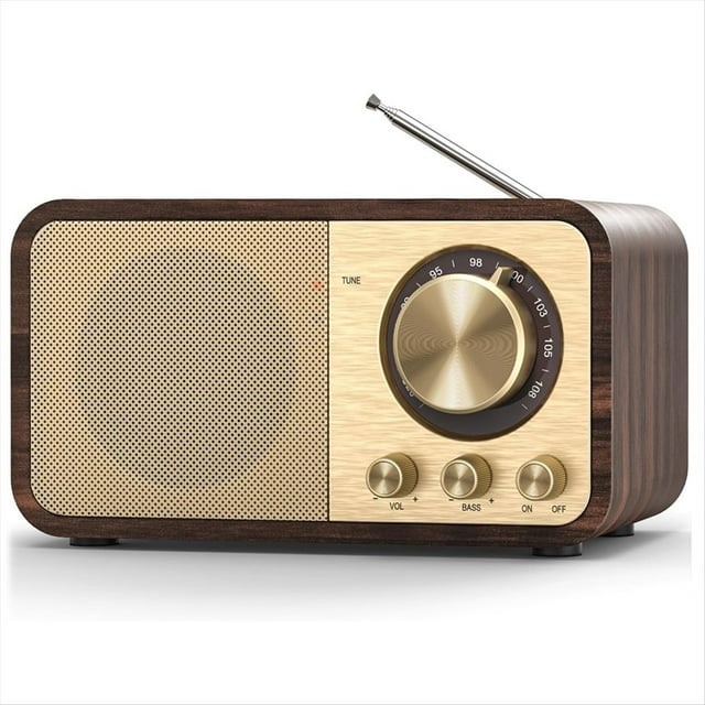 radio fm con recepción, radio portátil bluetooth con transistores y altavoz de 5 w, radios vintage recargables para el hogar y el exterior. 3/4 frontal de radio retro con carcasa de madera, rejilla de altavoz dorada a la izquierda, panel claro con gran perilla de sintonía marcada 87.5–108 MHz, tres mandos metálicos para volumen/bajos/encendido y antena telescópica extendida.