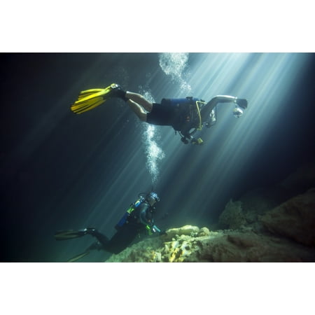 A young married couple scuba diving in Devils Den Springs Florida Poster
