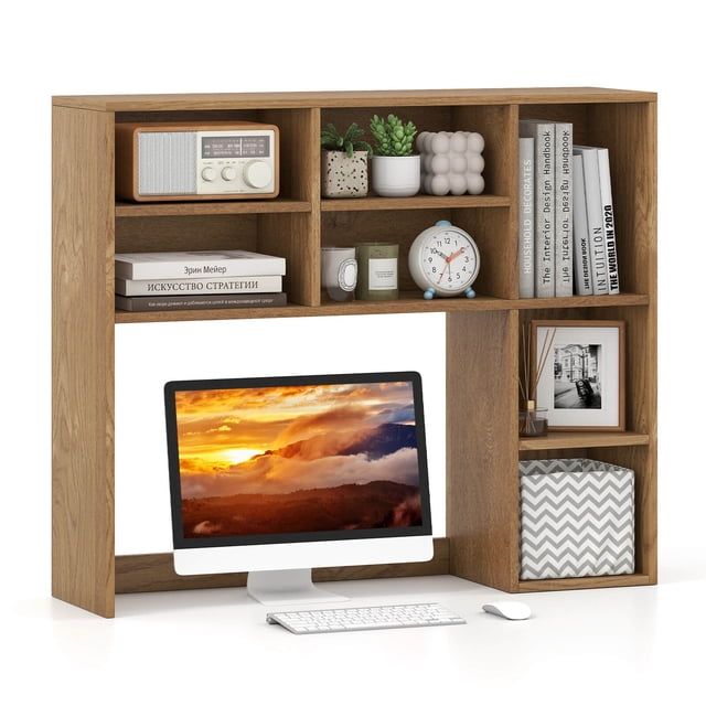 Costway Desktop Bookshelf Desk Storage Hutch with 7 Open Cubbies & 3 Adjustable Shelves in natural finish. This office furniture piece features a vertical design with a large bottom compartment fitting monitors up to 27 inches, 7 open cubbies for books, plants, and decor, and 3 adjustable shelves with 5 height options. Made of engineered wood and MDF, it includes anti-toppling devices and a reinforced crossbar for stability. Ideal for computer desks, writing desks, or vanity tables, and serves as a practical desk organizer.