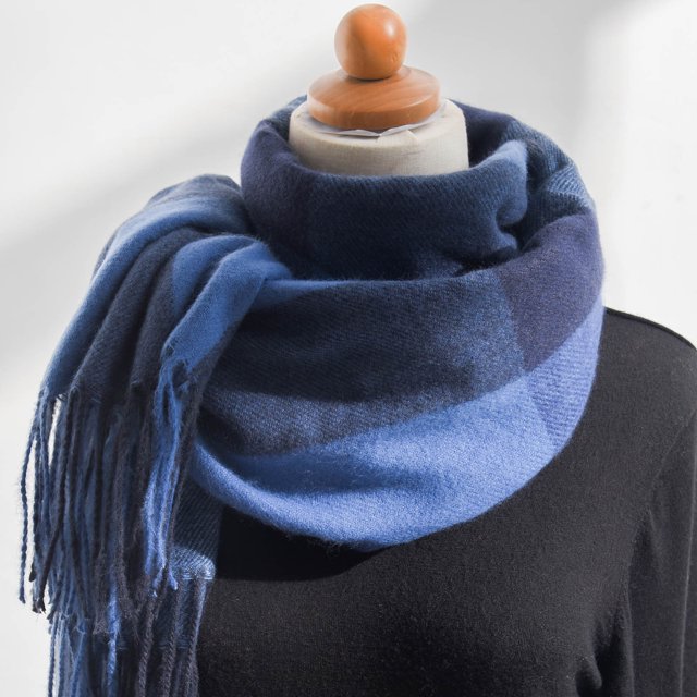 Up to 65% off Women's Fall Winter Scarf Classic Tassel Plaid Scarf Warm Soft Chunky Large Blanket Wrap Shawl Scarves Fashionable Scarf on Clearance. The image shows a mannequin wearing a soft, oversized plaid scarf in shades of blue and navy with tassel detailing. Made from imitation cashmere fabric, this scarf is cozy and warm, ideal for fall and winter. It can be styled as a shawl, wrap, or blanket, making it versatile for casual or formal occasions.
