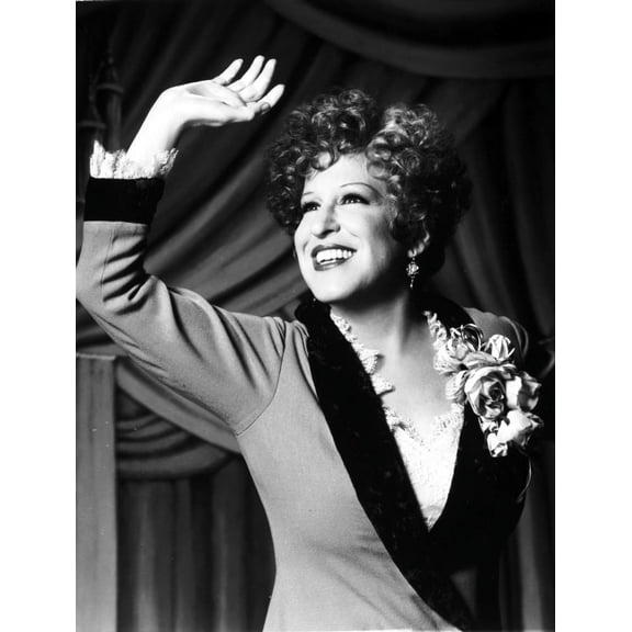 Bette Midler Portrait Waving Her Hand in Grey Linen Deep V-Neck Dress with White Ruffled Collar and Flower Corsage Photo Print (24 x 30)