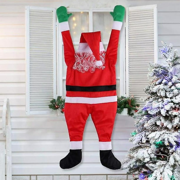 Papá Noel de terciopelo trepó a la pared para decorar ropa, colgar adornos y regalos de Navidad