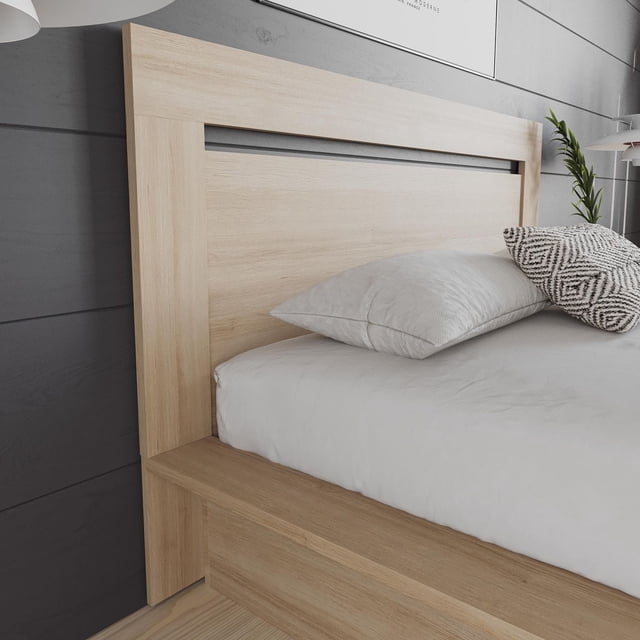 Nexera Malibu light wood headboard featuring a modern horizontal cutout design, shown as part of a bed setup with white sheets and decorative pillows.