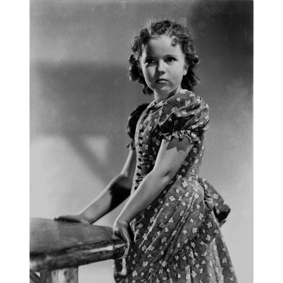 Shirley Temple Leaning in a Table in Floral Dress Photo Print (8 x 10)