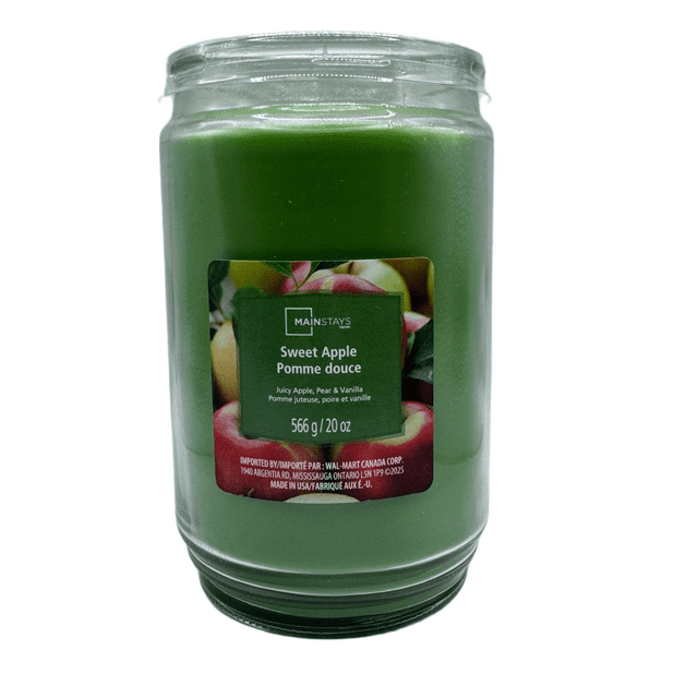 Green glass jar candle labeled MAINSTAYS Sweet Apple scented with notes of juicy apple, pear, and vanilla, 20 oz.