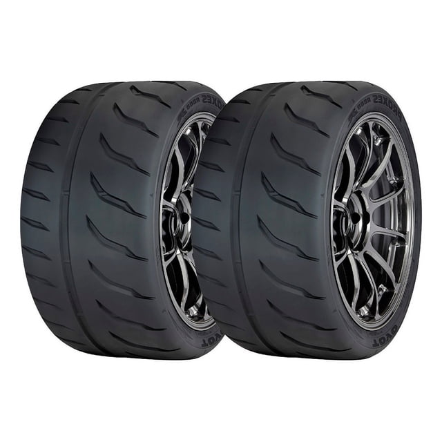 paquete 2 llantas 185/60r13 Toyo Proxes R888r Pxr8r 80v, dos neumáticos negros en vista 3/4 frontal sobre rines, perfil 185/60R13 con bandas de rodamiento direccionales, ranuras grandes y bloques de hombro visibles en el flanco con texto Toyo, fondo blanco neutro; suelen usarse en aplicaciones de alto rendimiento automotriz.