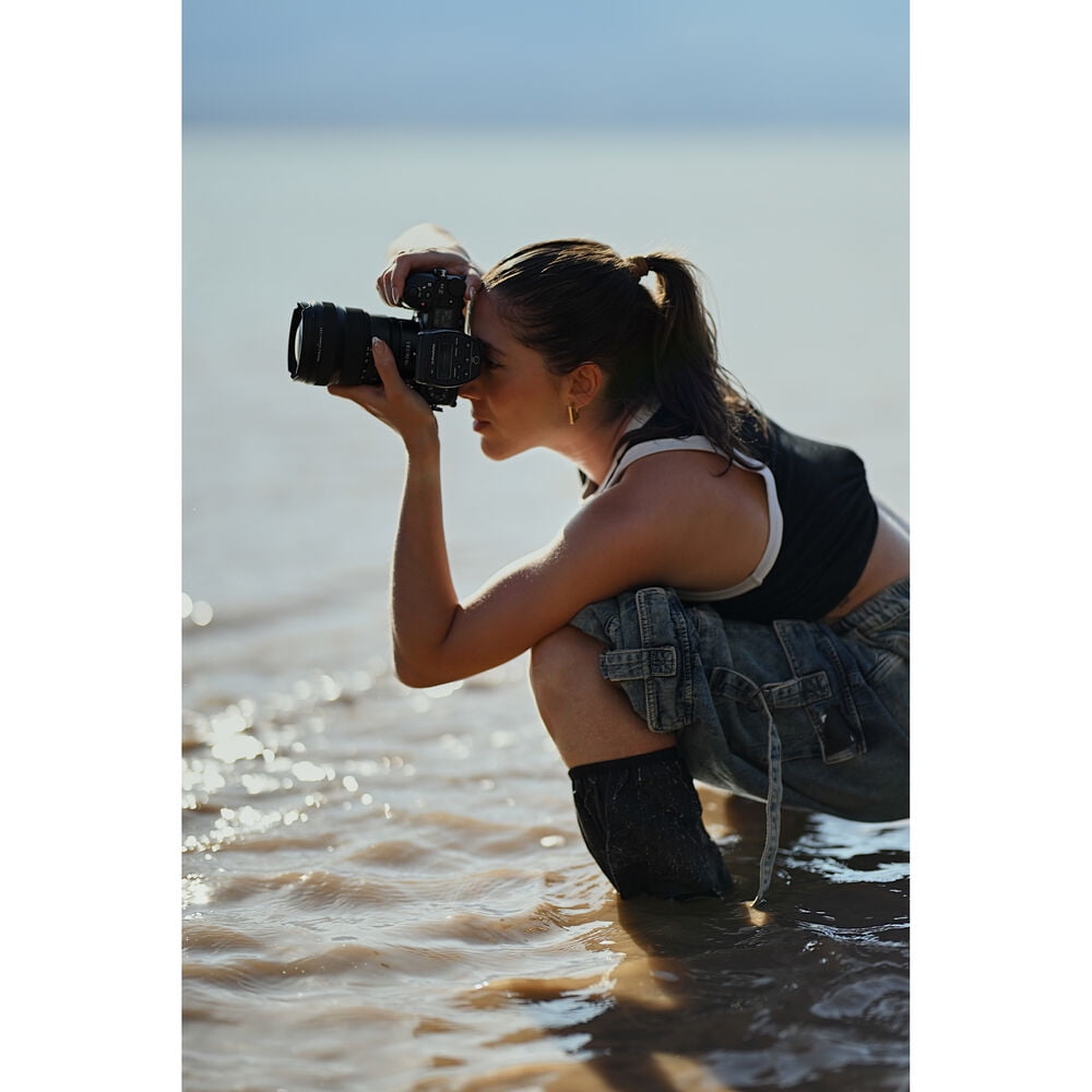 Girl taking pictures by the sea