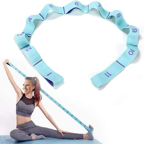 Black woman doing pilates workout using elastic strap sitting on yoga mat,  pulling training arms and shoulders in home living room. Athletic fit  exercising body using resistance band. Stock Photo