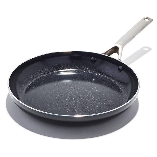 sartén oxo agility de cerámica antiadherente 30 cm vista 3/4 de sartén negra de 30 cm (12") con interior cerámico negro moteado y revestimiento antiadherente sin PFAS; cuerpo de aluminio de calentamiento rápido con borde biselado plateado y mango largo de acero inoxidable con remaches; base apta para inducción, horno y lavavajillas; sobre fondo blanco; también suele usarse para dorar y saltear por su calentamiento uniforme.