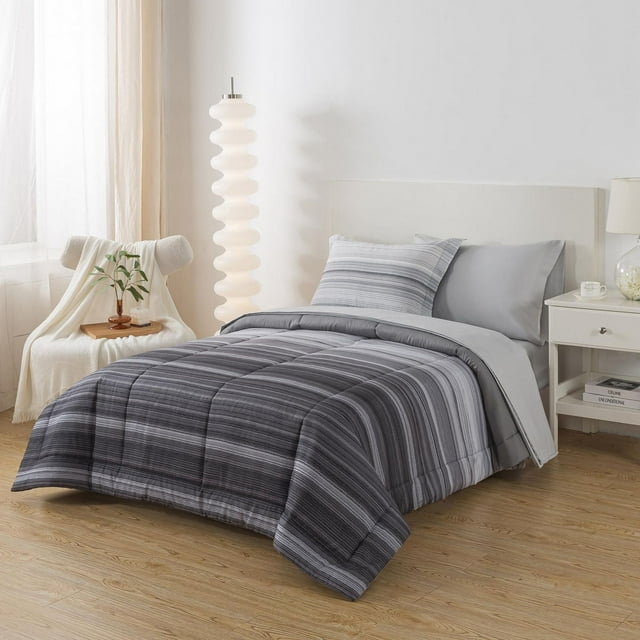 Mainstays Bed-in-a-Bag featuring a gray striped comforter set with matching pillow shams on a white bed frame in a bright, minimalist bedroom