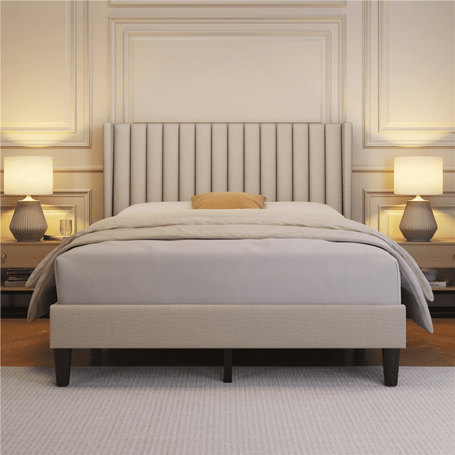 Full ivory upholstered bed frame featuring wing sides and a vertical channel headboard, styled in an elegant bedroom with matching bedside lamps.