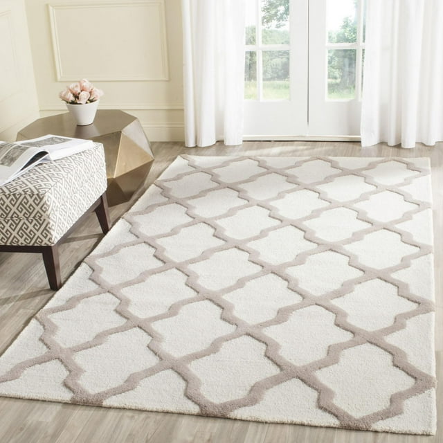 Safavieh Cambridge Liam Geometric Area Rug in cream with taupe lattice design on hardwood floor near window.