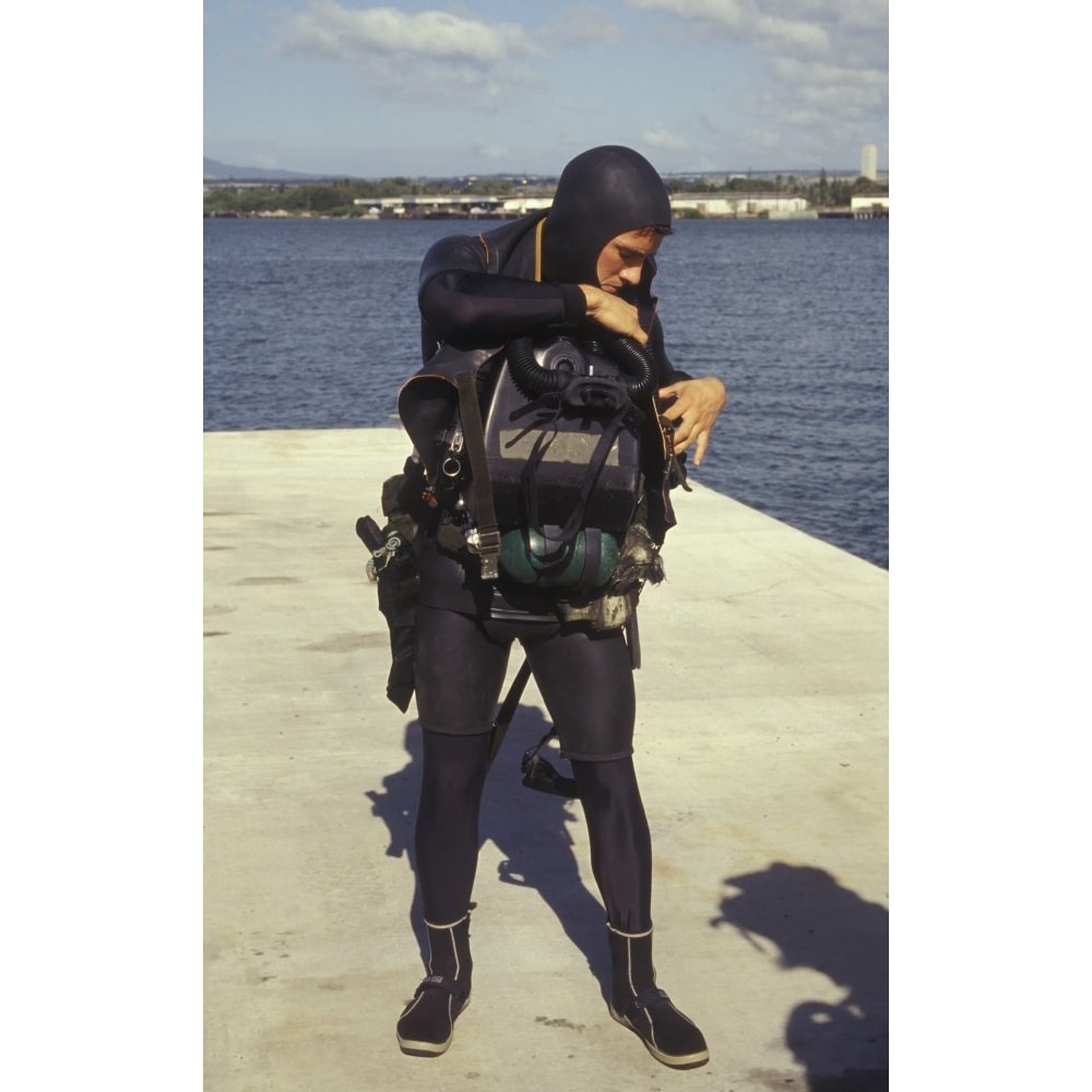 A Navy SEAL puts on a Draeger LARV oxygen rebreather in final preparation for combat swimmer