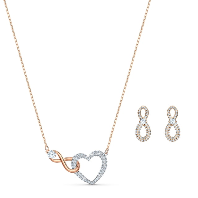 conjunto de joyas: collar y pendientes swarovski infinity con cristales Collar y aretes Swarovski en metal mixto, vista frontal centrada; collar con cadena ajustable de 14 7/8 pulgadas y colgante entrelazado de infinito y corazón pavéado con cristales transparentes y detalle de lazo rosado metálico, aretes perforados en forma de 8 con pavé de cristales sobre fondo blanco. A menudo usado como conjunto para ocasiones especiales o separado como accesorio diario.