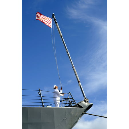 Joint Base Pearl Harbor-Hickam November 29 2011 - A sailor aboard the guided-missile destroyer USS Chafee readies to haul down the US Navy Jack as the ship departs on an independent deployment