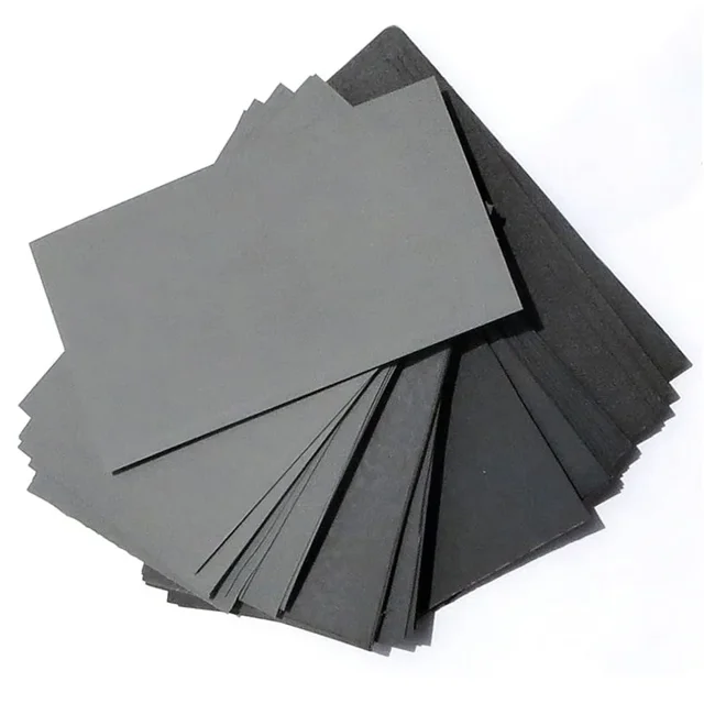 papel de lija de 10 piezas, herramientas abrasivas de lijado en seco con agua para pulir madera, vidrio y metal, grano 600/800/1000/1200/1500/2000/2500, hojas apiladas en abanico con grano 1500 especificado, superficie lisa en tonos gris oscuro y negro para pulido fino y retoques de acabado; a menudo usado también para pulir piezas pequeñas o instrumentos durante trabajos de detalle.