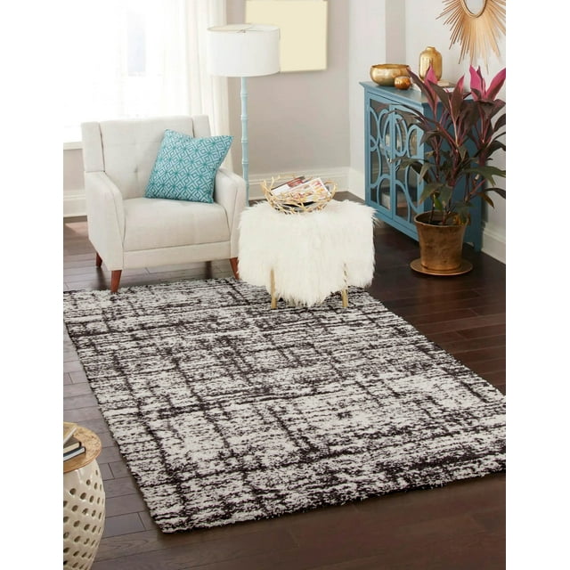 Plush ECARPET Colton contemporary area rug with black and white abstract design on dark hardwood floor, styled with beige armchair, blue cabinet, and decorative accents.